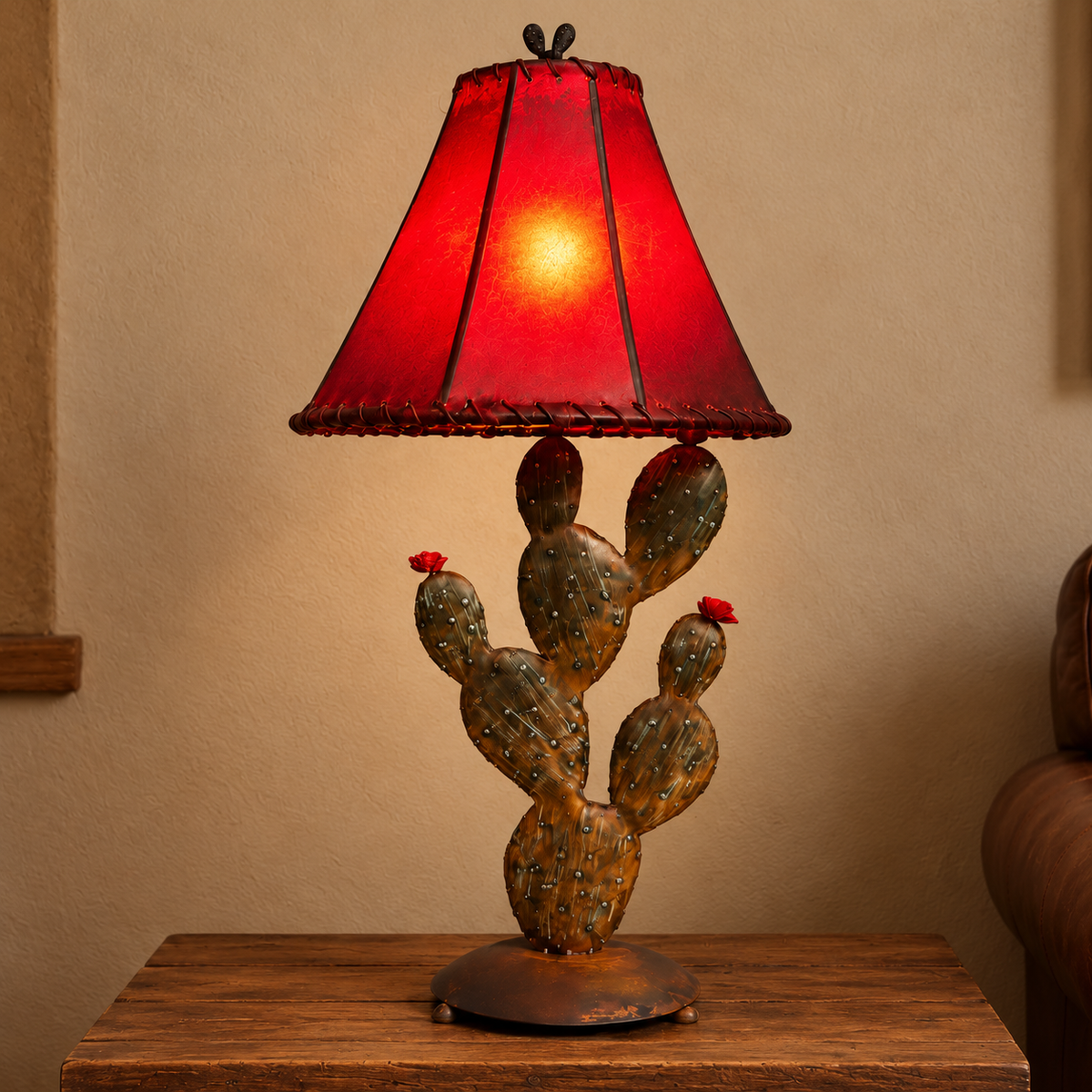 An iron desert cactus table lamp with a red 14" round rawhide lamp shade 