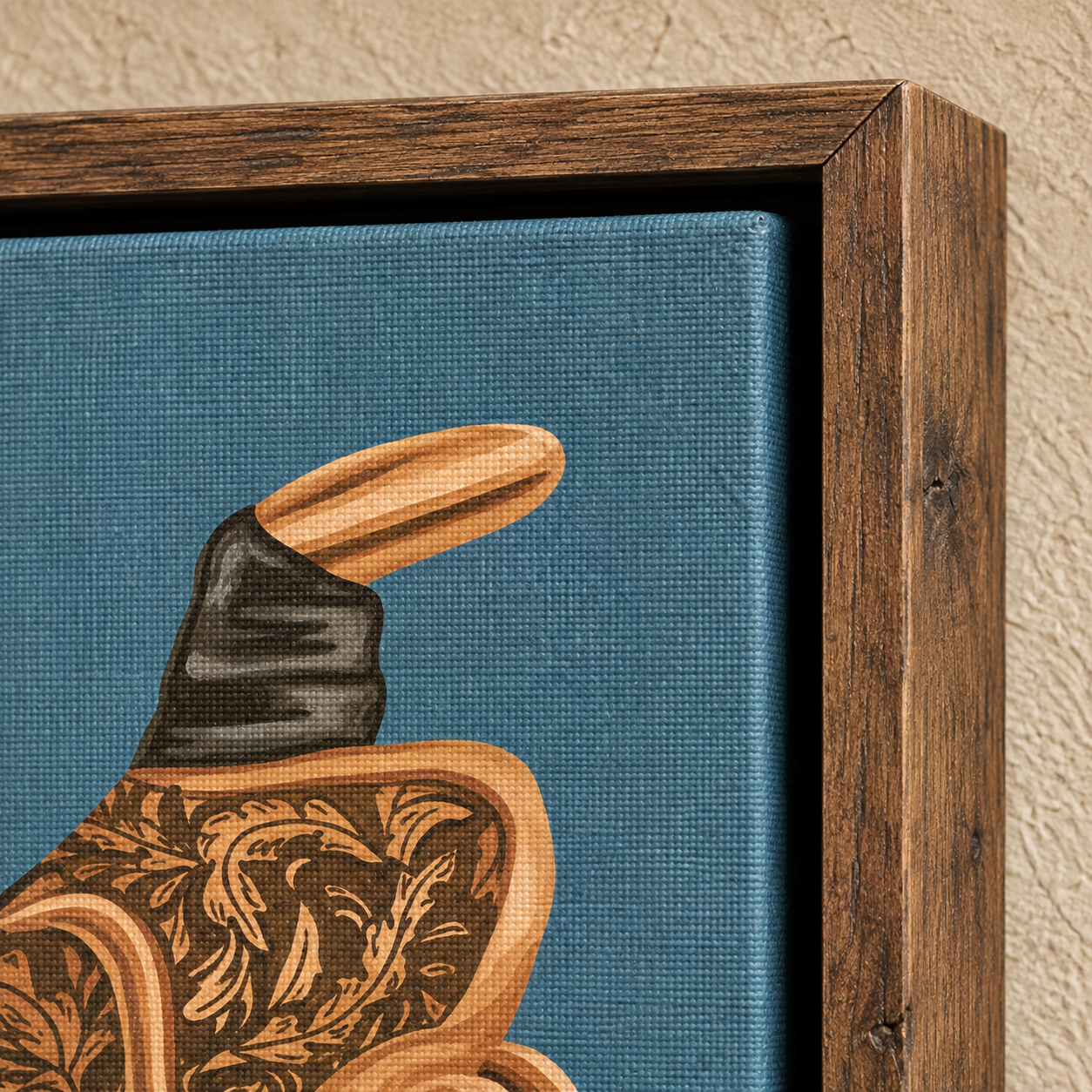 Close-up of a framed canvas art print showing part of a western boot illustration on a textured blue background, with a dark wood frame against a beige wall.