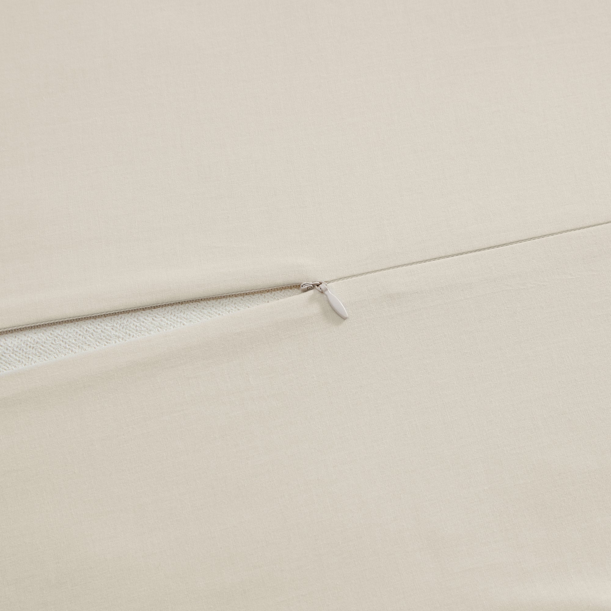 Close-up of beige fabric with a zipper detail