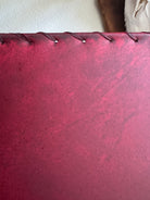 Up close detail of red rawhide and whip stitching 