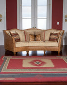 Brown sofa with patterned cushions on a red and blue geometric rug - Your Western Decor