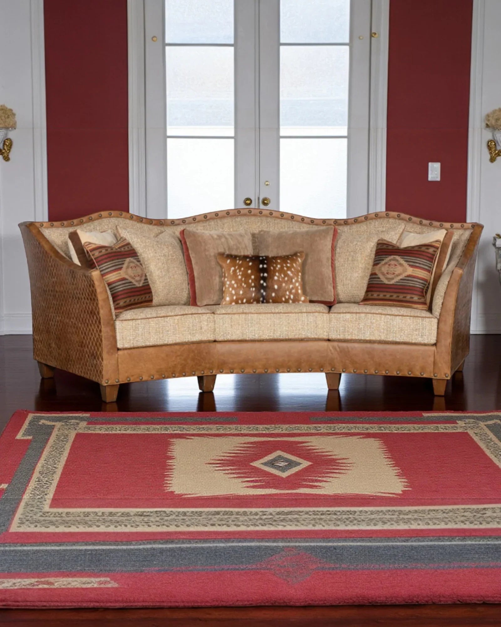 Brown sofa with patterned cushions on a red and blue geometric rug - Your Western Decor