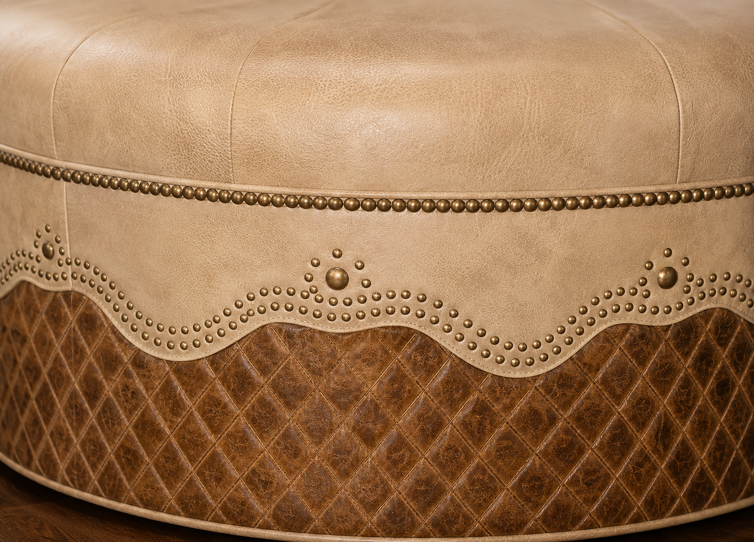 Close-up showing embossed diamond leather, nail trim, and hand-finished artisan leather on round ottoman