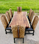 Wooden dining table with eight chairs featuring deer print patterns outdoors - Your Western Decor