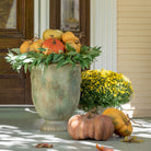Decorative urn with pumpkins and greenery on a porch - Your Western Decor