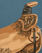 A close-up of a western leather saddle with ornate floral embroidery and a black leather strap, shown against a textured blue background.
