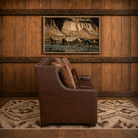 Side profile of luxury western leather sofa with sloped arms and handcrafted detailing