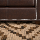 Close-up of leather sofa seat rail with silver nail trim and premium leather texture