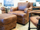 Brown leather armchair and ottoman in a room with other furniture - Your Western Decor