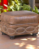 Brown leather ottoman with decorative stitching on a patio - Your Western Decor