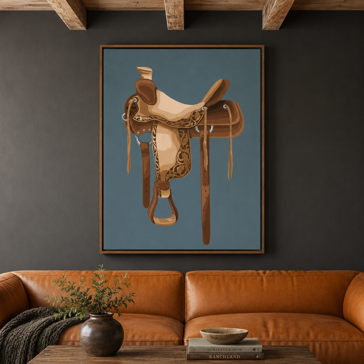 A framed art print featuring a detailed western saddle illustration on a muted blue background, displayed on a dark gray wall above a brown leather sofa with a wooden coffee table and vase in the foreground.