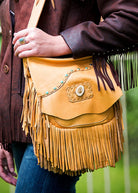Tan Frontier Leather Handbag with fringe, a laced natural-edge flap, faux turquoise accents, and a genuine antler button