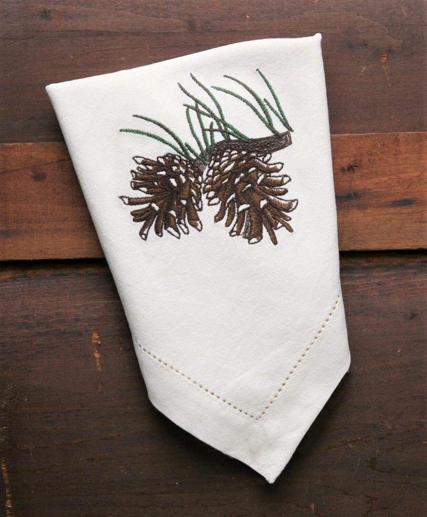 Ivory cloth napkins with embroidered pine cone design. Your Western Decor