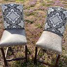 Bar stools with grey leather seat, black, white, and grey fabric backs, and nail trim