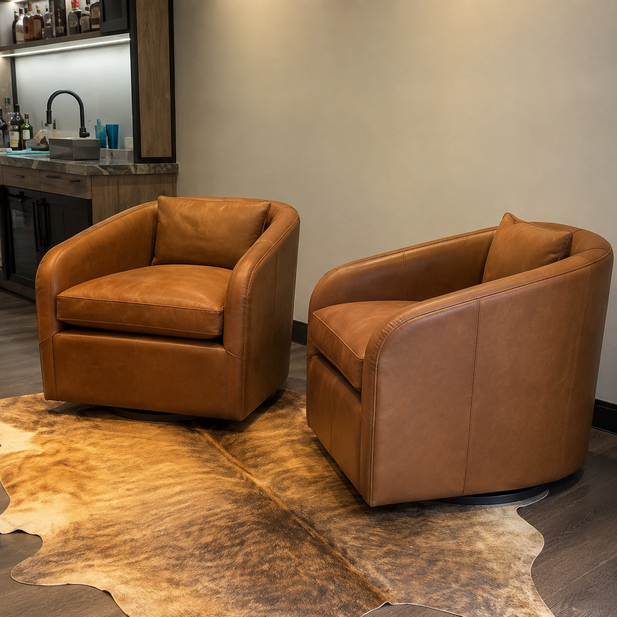 Two brown leather swivel chairs with rounded arms and back cushions, placed on a cowhide rug in a modern interior setting.