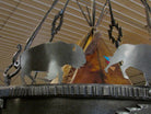 Black finished iron buffalo cutout silhouettes flanking a hand-painted teepee sculpture on a decorative metal frame.