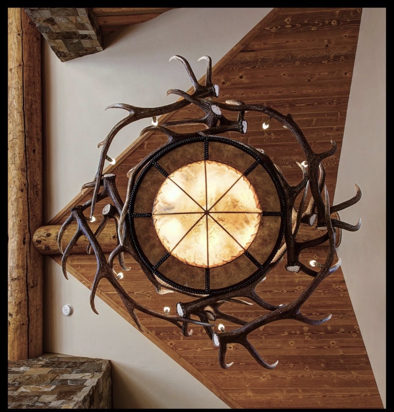 Decorative ceiling light fixture with antler design in a rustic setting