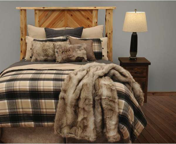 Bedroom with wooden headboard, plaid bedding, and fur throw blanket.