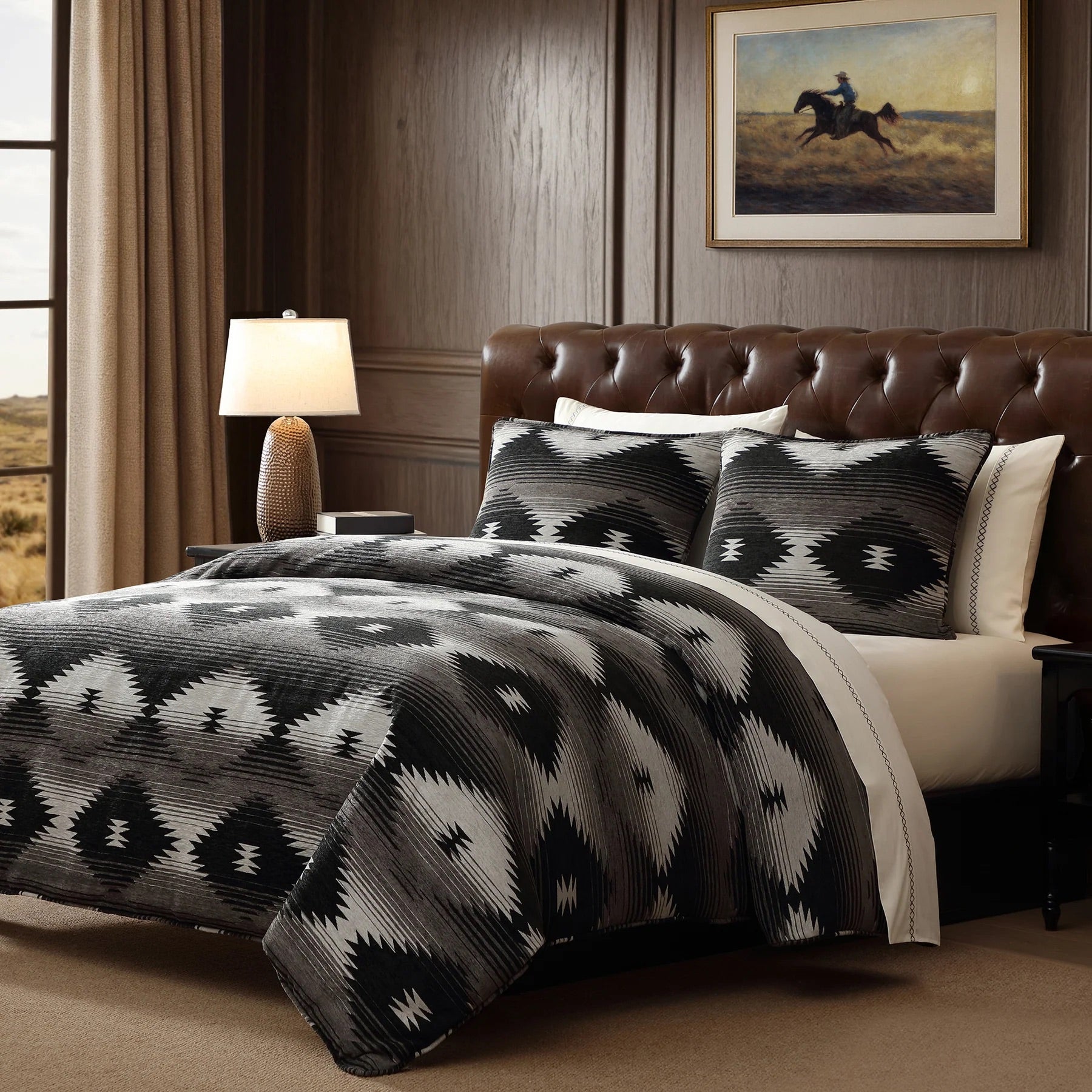Bedroom with a brown leather headboard, patterned comforter, and framed artwork on the wall.