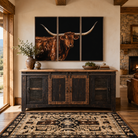 Rustic Western console cabinet staged in a bright luxury ranch home with Southwestern area rug and framed Texas longhorn wall art above, featuring reclaimed wood tones, iron mesh doors, stone fireplace, and warm lodge-style decor.