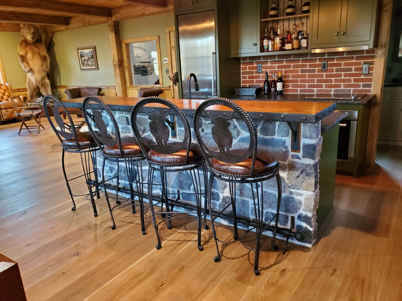 Custom made iron swivel bar stools with leather seats and iron highlander cows