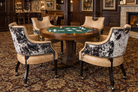 Poker table with ivory leather and peppered cowhide chairs in a room with wooden furniture and decor.