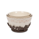 Cream embossed stoneware nesting bowl set with decorative iron stand.