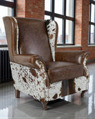 Brown leather armchair with cowhide pattern in a room with large windows and brick walls - Your Western Decor