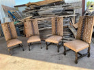 Four wooden chairs with upholstered seats and backrests in front of a pile of wooden planks - Your Western Decor