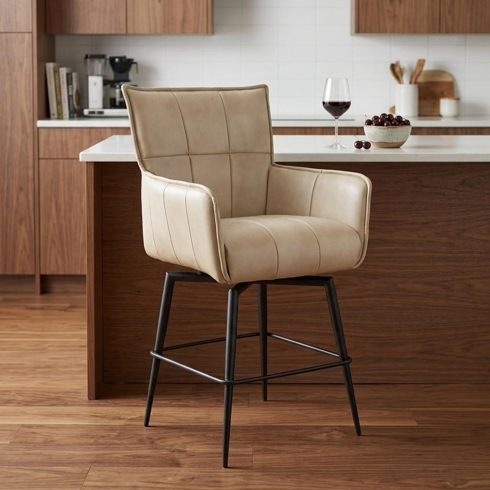Beige leather counter stool in a kitchen setting with wooden cabinets and a countertop.