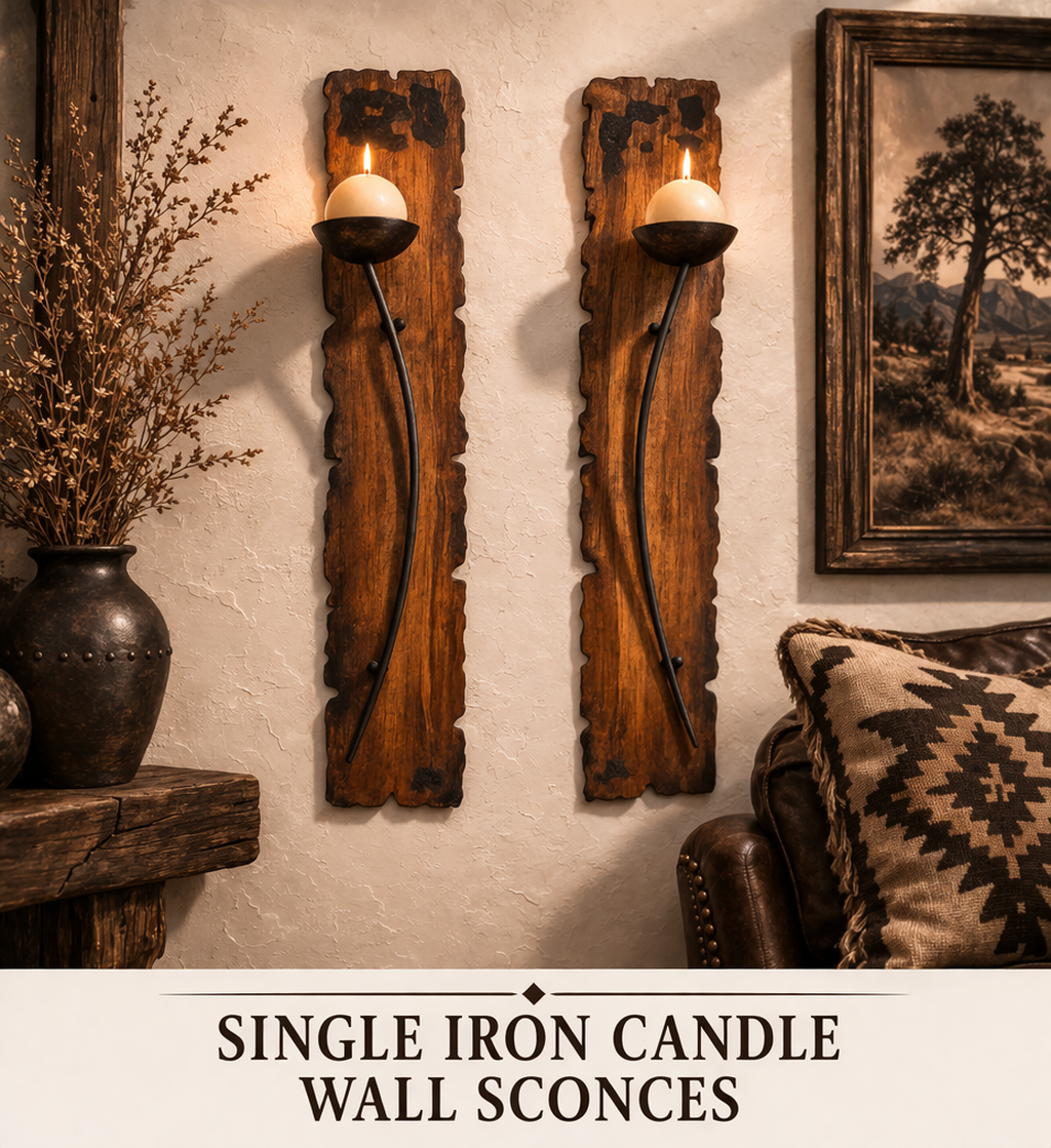 Pair of hand forged iron candle wall sconces on textured wall with wood cabinet and plant western decor