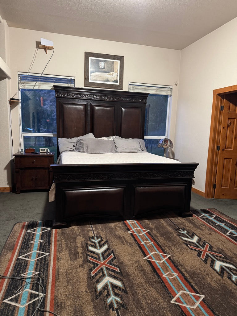Carved wood bed with leather upholstered on Southwestern area rug