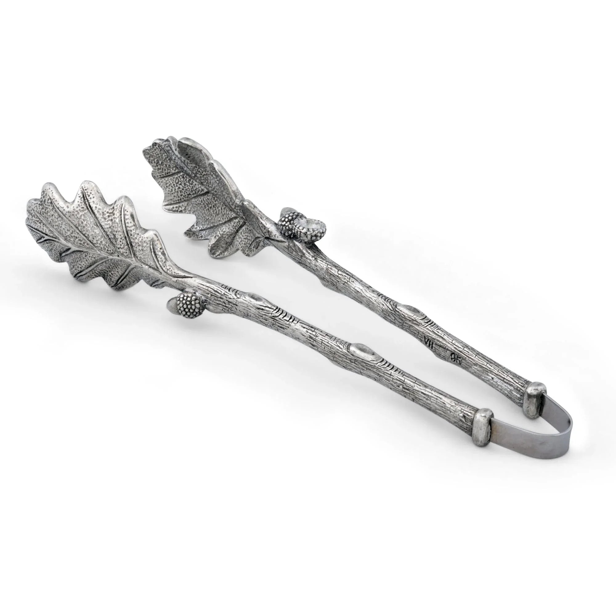 Decorative silver tongs with leaf design on a white background