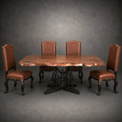 A rustic dining table set with a live-edge wood tabletop on a black metal pedestal base, accompanied by four matching chairs upholstered in brown leather, set against a dark gray studio background.