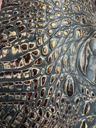 Detail of brown croc embossed leather with metallic highlights