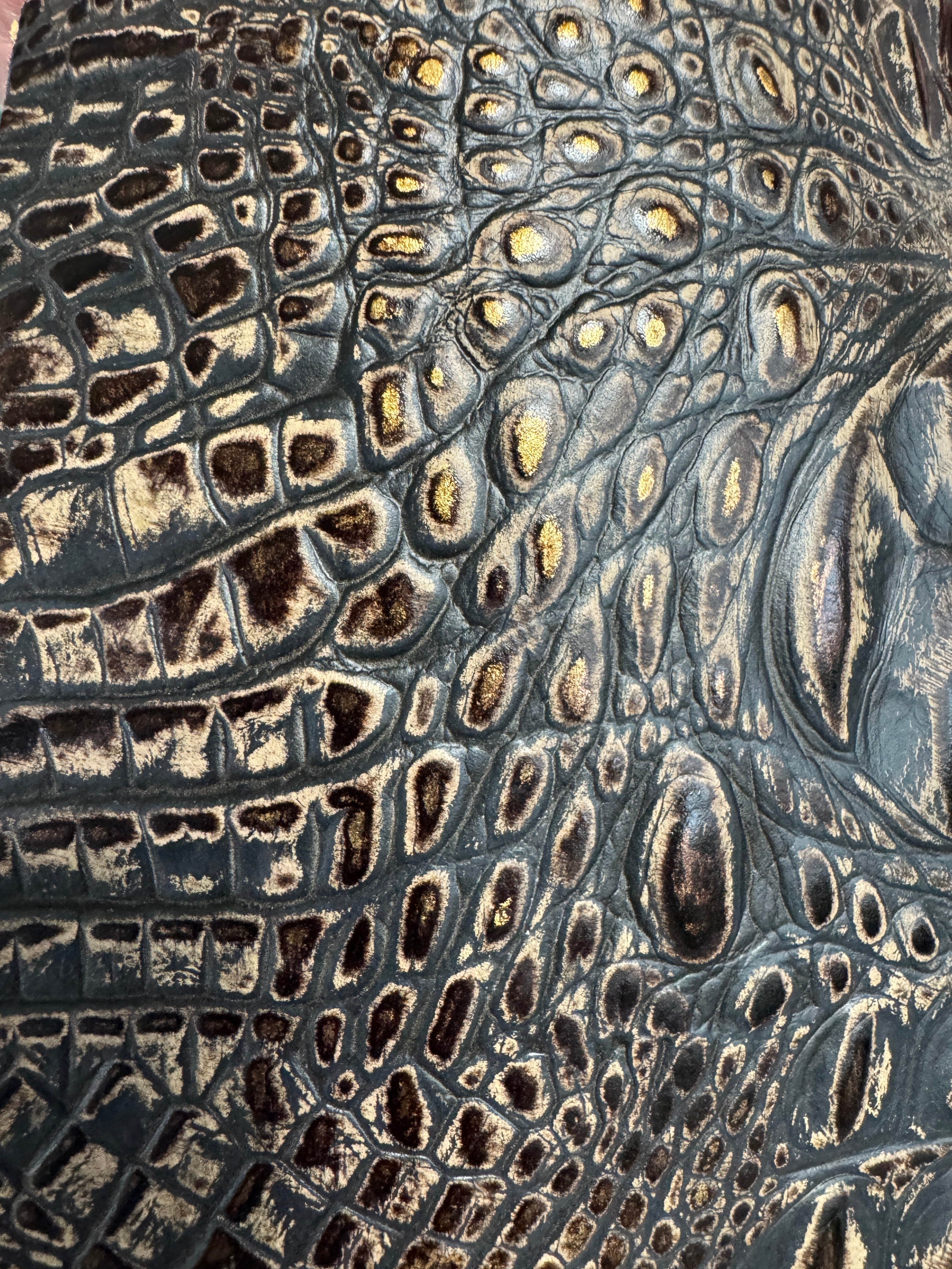 Detail of brown croc embossed leather with metallic highlights