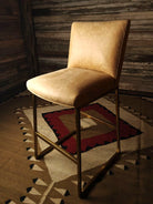 Beige leather chair on a patterned rug with wooden wall background - Your Western Decor