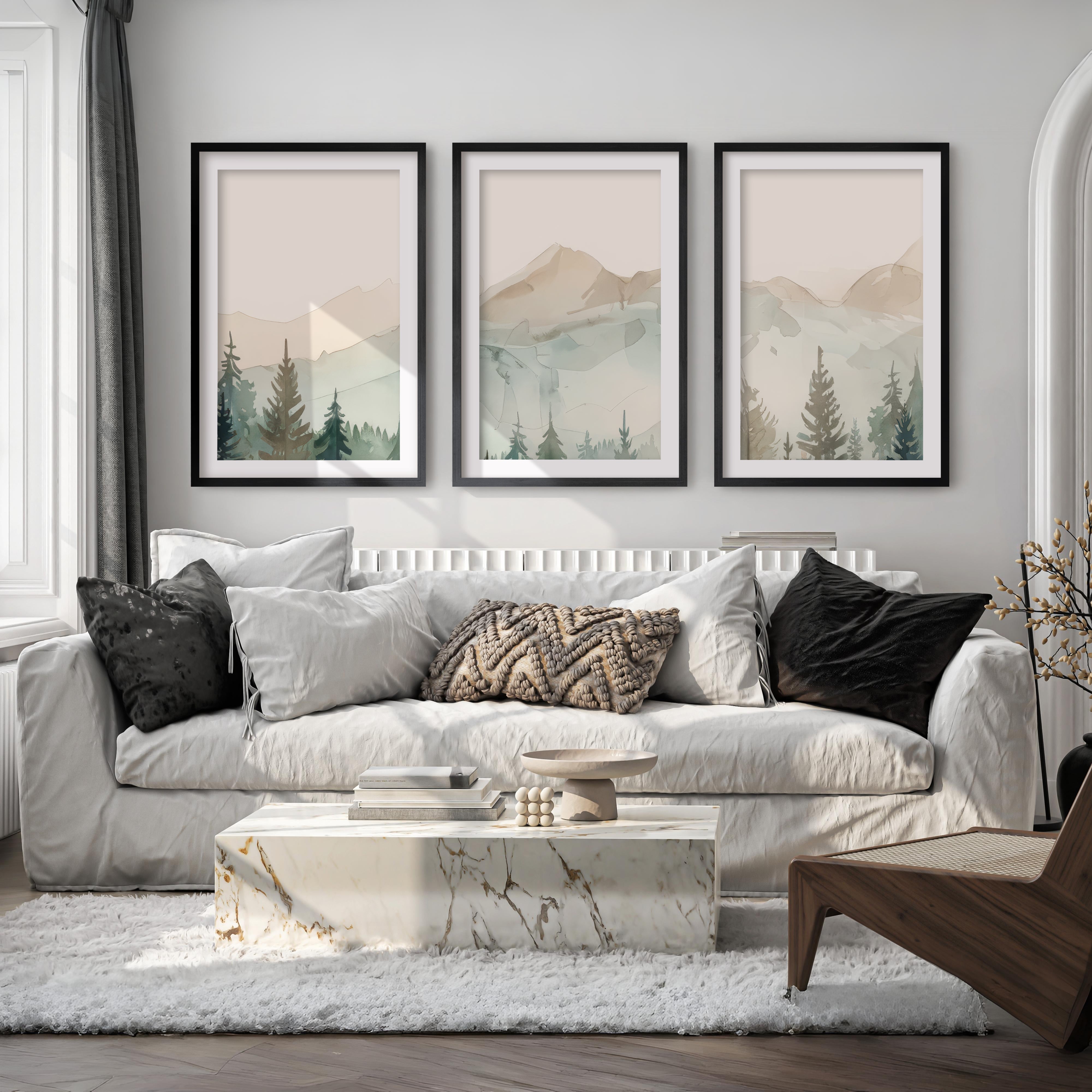 Living room with a white sofa, marble coffee table, and framed mountain landscape art.