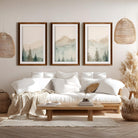 Watercolor triptych mountain scene art set with brown wood frames and white border in boho style living room 
