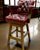 Red leather bar stool with wooden legs in a room with large windows - Your Western Decor