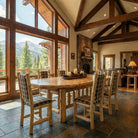 cedar log oval dining table in luxury mountain home with large windows