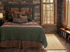 Rustic bedroom with wooden walls, bed with patterned bedding, and window view - Your Western Decor
