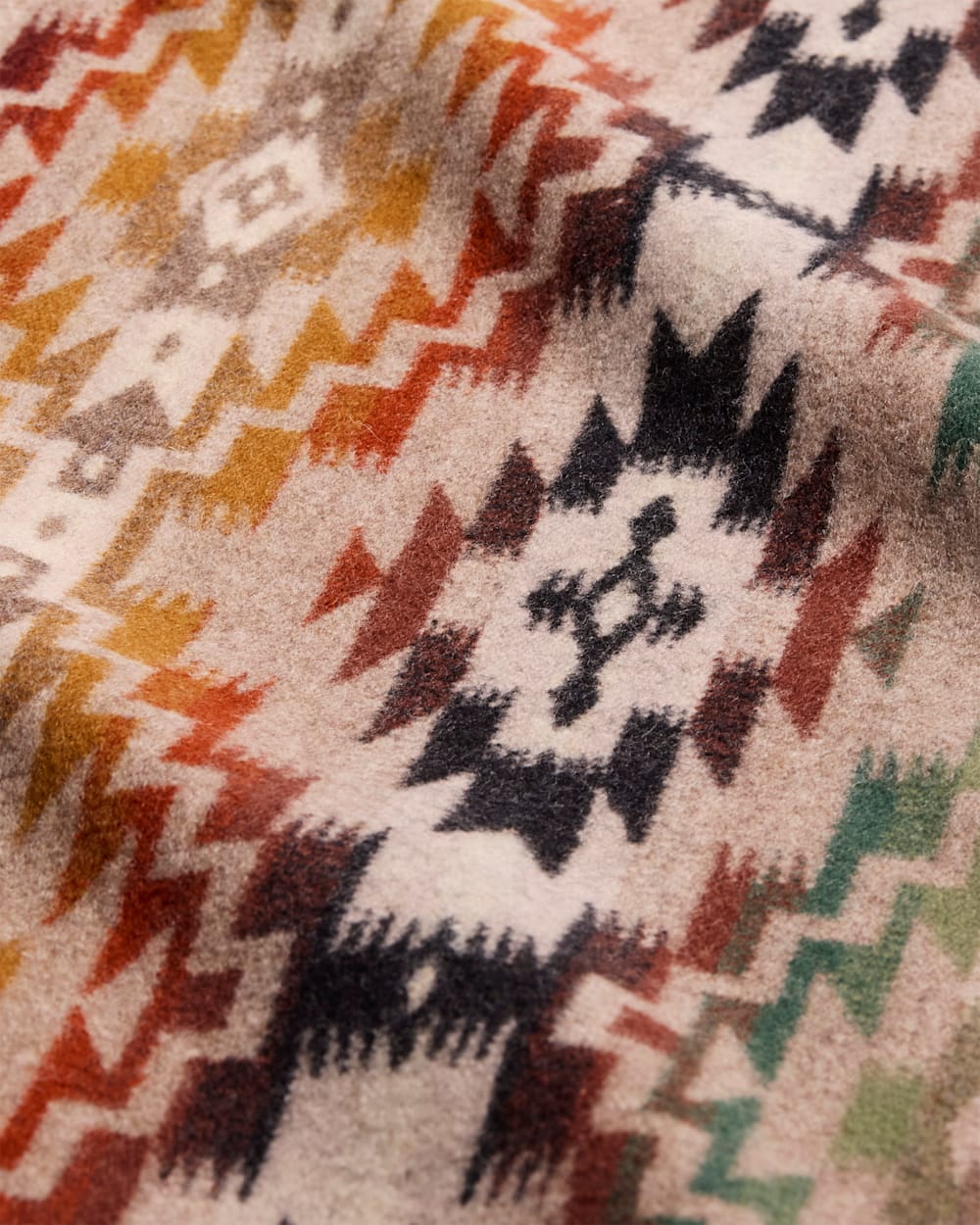 Detail of Pendleton Mesilla southwestern wool fabric with geometric diamond pattern in clay, sage green, ivory, and black, blanket-weight jacquard upholstery fabric