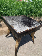 Longhorn steer leg side table with peppered cowhide surface and nail trim 