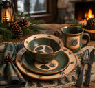 pinecone dinnerware set with rustic lodge table setting featuring green stoneware plates bowl and mug on wooden table with pine accents and warm lighting