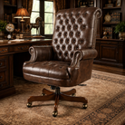 A luxury brown leather swivel office chair with a high tufted backrest, rolled arms, and a wooden five-star base, set in a classic, warm-toned study room.