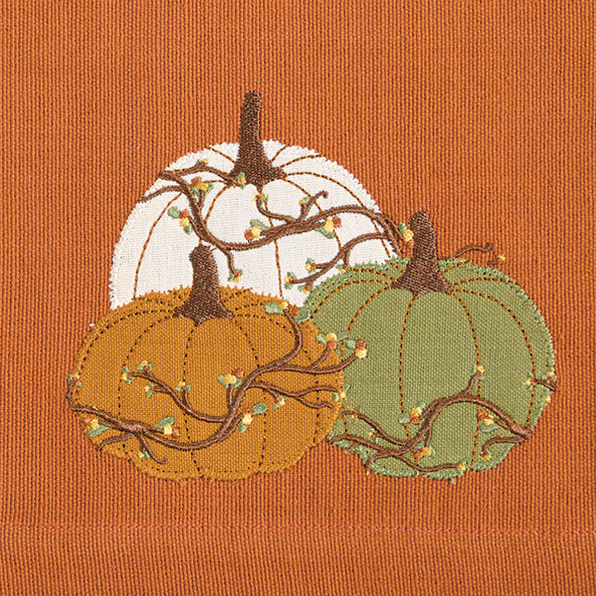 Embroidered pumpkins on a burnt orange fabric background - Your Western Decor