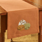 Brown table runner with embroidered pumpkins on a wooden table - Your Western Decor