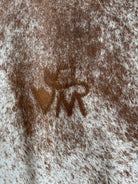 Peppered brown and white cowhide rug with ranch brand