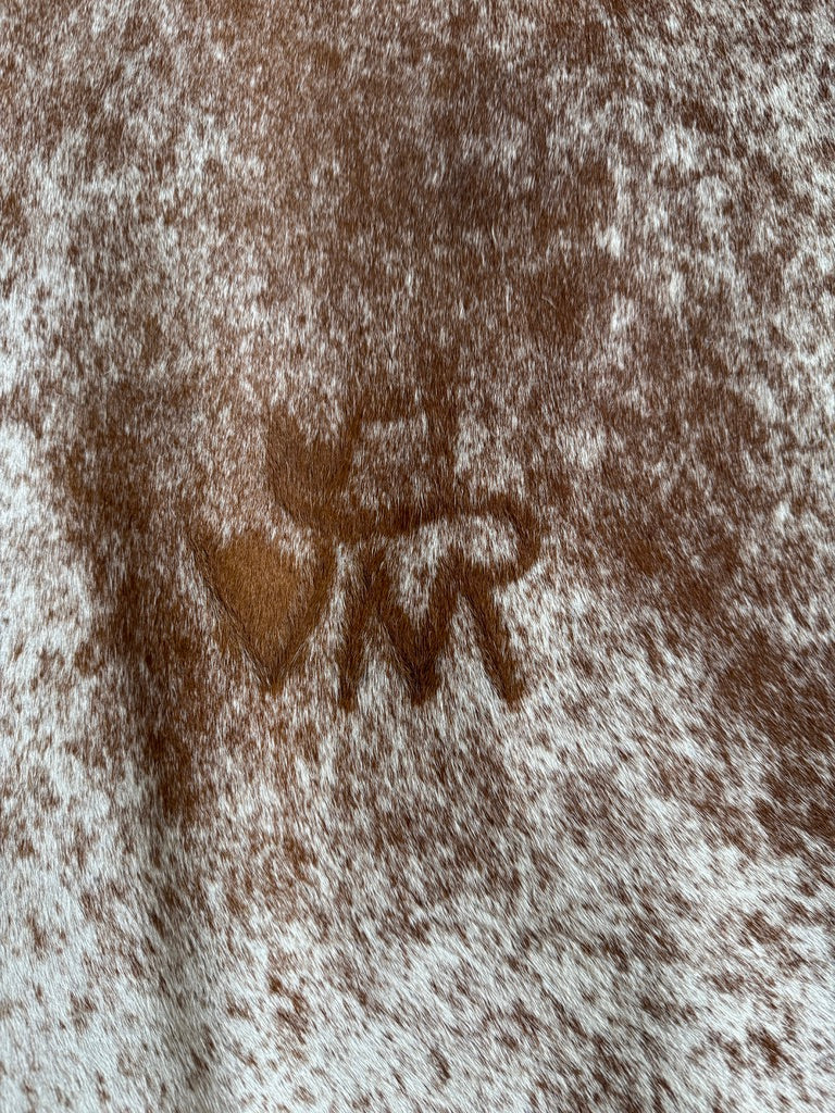 Peppered brown and white cowhide rug with ranch brand